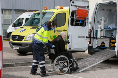 Un sanitario introduce a una persona mayor en una ambulancia en el aparcamiento del HUBU. RAÚL OCHOA
