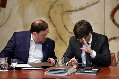 El 'president' Carles Puigdemont y el vicepresidente Oriol Junqueras conversan antes de la reunión del Govern de este martes.-FERRAN NADEU