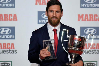 Messi, con el trofeo Pichichi y el trofeo Di Stéfano, que le entregó el diario Marca.-AFP / LLUIS GENE
