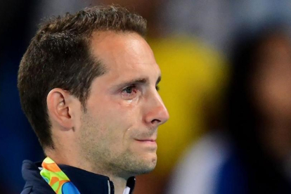 El pertiguista francés Renaud Lavillenie no puede reprimir las lágrimas durante la ceremonia de entrega de medallas.-FRANCK FIFE / AFP