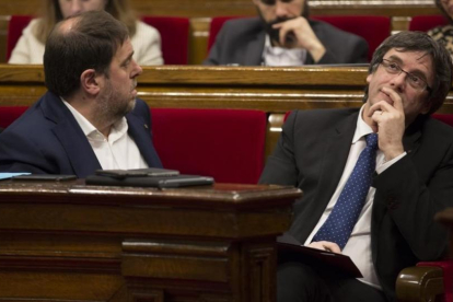 El 'president' Carles Puigdemont y el vicepresidente Oriol Junqueras, en el hemiciclo del Parlament.-ALBERT BERTRAN