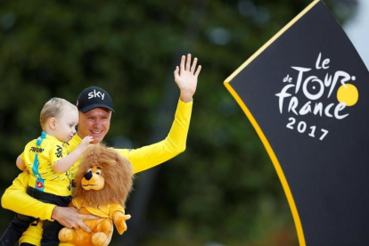 Chris Froome con su hijo, en el podio de París.-REUTERS / CHRISTIAN HARTMANN