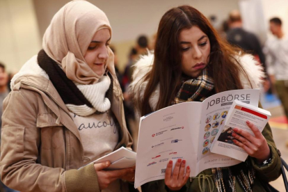 Dos mujeres visitan la segunda feria del trabajo para los inmigrantes y los refugiados celebrada en Berlín en el 2015.-REUTERS / FABRIZIO BENSCH