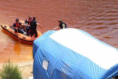 Miembros de los servicios de rescate navegan por el Lago Rojo mientras buscan nuevas pistas de los crímenes.-EFE