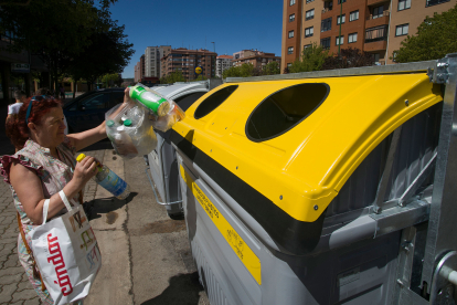 Una mujer recicla envases de plástico en el nuevo contenedor del barrio de Vista Alegre. TOMÁS ALONSO
