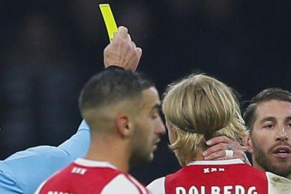 El árbitro Damir Skomina enseña la tarjeta amarilla a Sergio Ramos.-AP / PETER DEJONG