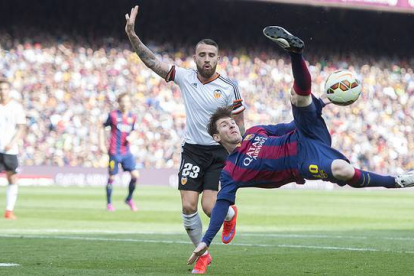 Messi chuta acrobáticamente ante Otamendi, durante el Barcelona-Valencia en el Camp Nou.-Foto: JORDI COTRINA