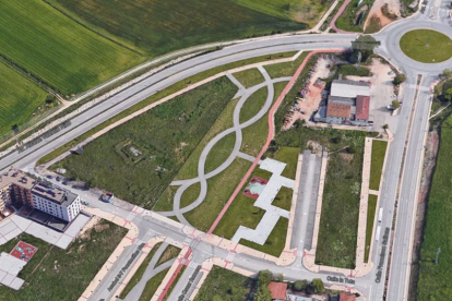 En esta imagen aérea se puede observar que las obras se pararon a mitad de un vial y junto a la glorieta los almacenes de materiales de construcción.-ECB