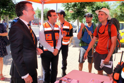 El concejal de Seguridad y Movilidad de León, Fernando Salguero (I), conversa con dos peregrinos norteamericanos durante la presentación de la campaña-Ical