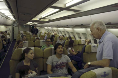 El ministro de Asuntos Exteriores, José Manuel García-Margallo (d), conversa con varios de los españoles rescatados tras el terremoto de Nepal en el avión que les ha traído a España desde Nueva Delhi.-Foto: EFE