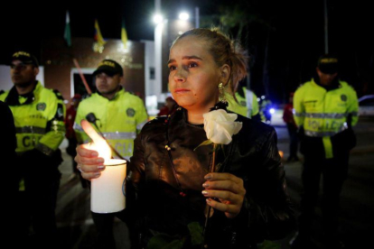 Ciudadanos y policias participan en un planton frente a la Escuela de Cadetes de Policia General Francisco de Paula Santander  en Bogota  Colombia  para recordar a quienes murieron  en un atentado perpetrado con un carro bomba .-EFE