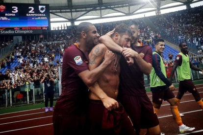 Totti es abrazado por sus compañeros del Roma tras marcar de penalti el gol de la victoria contra el Sampdoria.-AP / ANGELO CARCONI