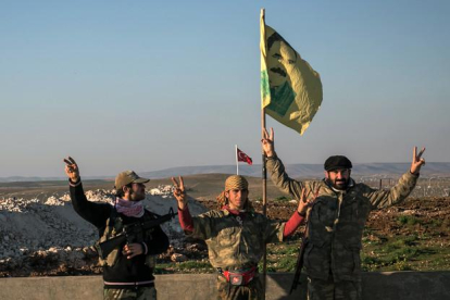 Milicianos kurdos con una bandera del líder del PKK, Abdulá Ocalán, en las cercanías de la ciudad siria de Alepo.-AP / MURSEL COBAN