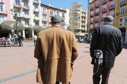 Dos pensionistas paseando por la plaza Mayor de la capital burgalesa.-ISRAEL L. MURILLO