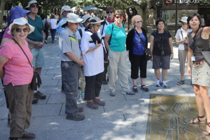Un grupo de visitantes atiende las explicaciones de una guía de turismo en el paseo de El Espolón.-ISRAEL L. MURILLO