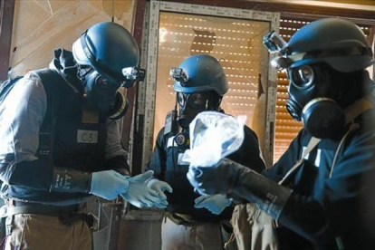 Supervisión - Unos inspectores examinan material en una zona atacada con armas químicas en Siria. /-REUTERS