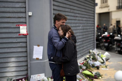 Una pareja se abraza frente a los restaurantes Le Carillon y Le Petit Cambodge, este sábado.-AP / JEROME DELAY
