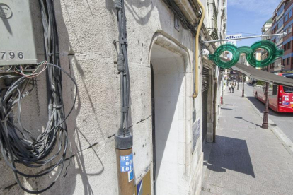 En primer plano, caja de cableado de fibra óptica instalado en la fachada de un edificio de la calle San Pablo.