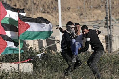 Manifestantes evacuan a un herido en las protestas de este sábado en Gaza.-/ EFE / MOHAMMED SABER