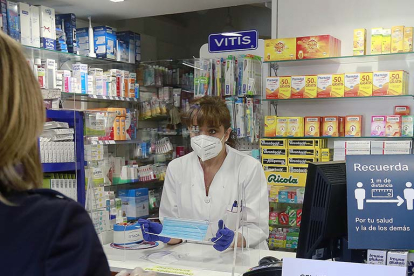 Una clienta compra una mascarilla en una farmacia. RAÚL OCHOA