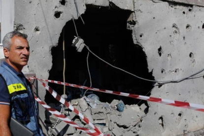 Un israelí inspecciona una casa dañada en la franja de Gaza.-COHEN MAGEN (AFP)
