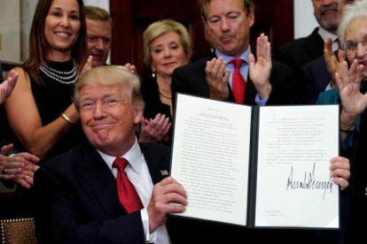 Trump, sonriente, tras firmar una orden ejecutiva contra el Obamacare, el pasado 12 de octubre.-REUTERS / KEVIN LAMARQUE
