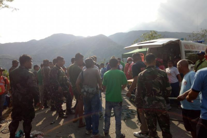 Fotografía cedida por la Estación de Policía del municipio de Carranglan donde se ve a ciudadanos filipinos, soldados y policías sosteniendo una cuerda para recuperar los cuerpos de las víctimas del accidente.-EFE