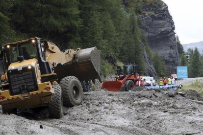 Excavadoras tratan de limpiar la carretera para el paso del Tour de Francia.-AP /  / THIBAULT CAMUS