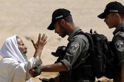 Un palestino discute con soldados israelís el pasado junio al sur de Hebrón.-EFE