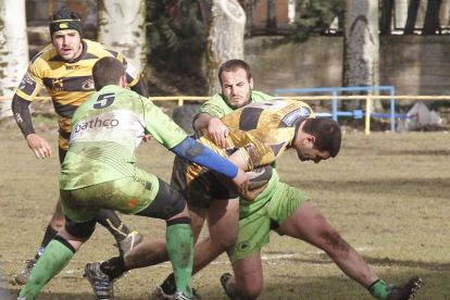 Pablo Sáinz intenta escapar del acoso de dos jugadores del Bathco B, ayer, en San Amaro.-SANTI OTERO