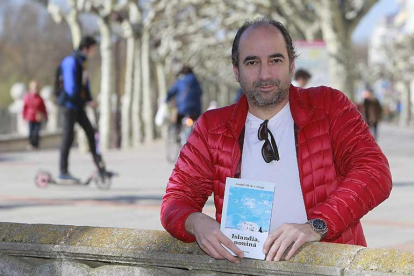 Ismael Ali de Unzaga posa en el paseo del Espolón con uno de los ejemplares de ‘Islandia, noniná’, su primera novela.-Raúl Ochoa