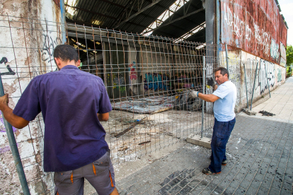 Dos operarios vallan el acceso a la fábrica de Mifer la en carretera de Arcos. FOTOS: © ECB/ TOMÁS ALONSO