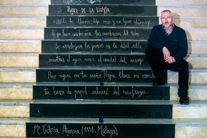 Jesús Arranz, en las escaleras del hall de IES Pintor Luis Sáez que reproducen un poema de la 'poeta de guardia' de este mes de marzo, María Victoria Atencia. TOMÁS ALONSO