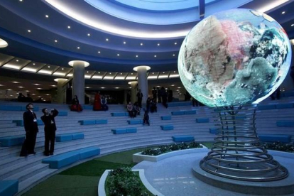 Un visitante toma fotos de un modelo de globo terrestre en el complejo Sci Tech de Pionyang, este miércoles.-AP / KIM KWANG HYON