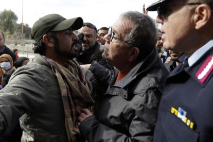 Inmigrantes afganos intentan bloquear la entrada del ministro al centro de refugiados.-THANASSIS STAVRAKIS