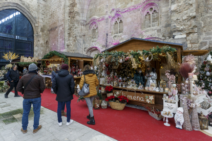 Varias personas observan los puestos de flores en la Feria Florista de Navidad, en el Monasterio de San Juan. SANTI OTERO