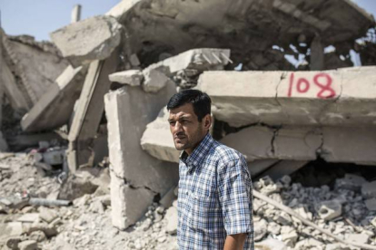 Abdullah Kurdi, el padre de Aylan Kurdi, ante las casas derruidas de sus vecinos, en Kobani.-YASIN AKGUL / AFP