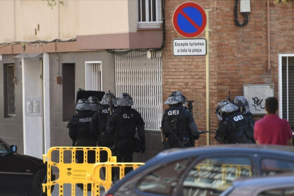 Los Mossos d'Esquadra entran en la finca en la que residía el atacante de la comisaría de Cornellà, este lunes. /-JORDI COTRINA