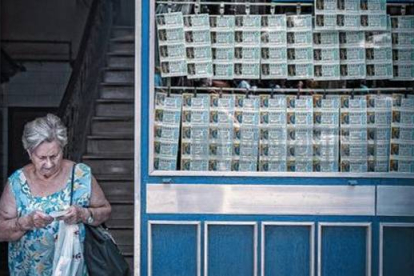 Una mujer sale de una administración de lotería en las Rambles de Barcelona.-Foto: JOAN CORTADELLAS