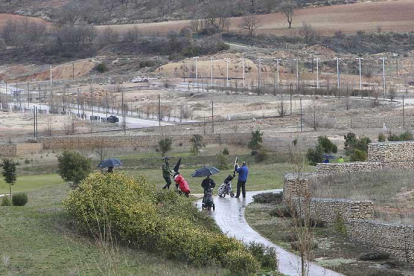 Varios jugadores realizan un recorrido por el Golf de Saldaña con las parcelas al fondo, urbanizadas y sin edificar de la urbanización en que se enclava.-RAÚL OCHOA