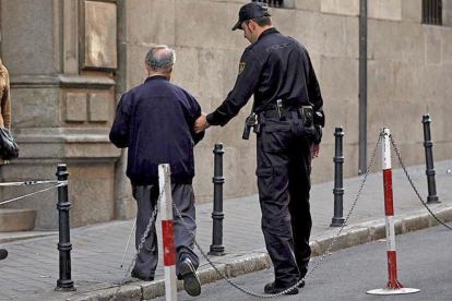 Un agente ayuda a una persona mayor.-ECB