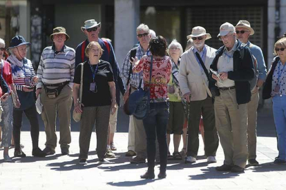 Una guía turísitica ofrece una explicación a un grupo de turistas.