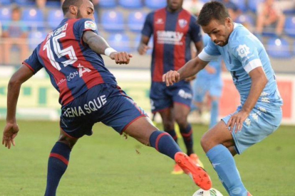 El jugador del Girona, Felipe Sanchón, trata de marcharse del defensa del Huesca, Carlos Akapo.-@GironaFC