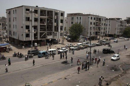 Civiles y fuerzas de seguridad permanecen a las afueras de la comisaría de policía atacada, este jueves, en el centro de Adén.-NARIMAN EL-MOFTY (AP)