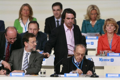 José María Aznar pasa por el lado de Mariano Rajoy, sentado junto a Manuel Fraga, en la clausura del XVI congreso nacional del PP, en el 2008 en Valencia-MIGUEL LORENZO