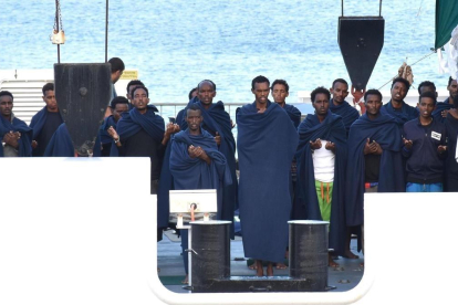 Un grupo de personas reza a bordo del Diociotti, atracado desde hace unos días en el puerto de Catania (Sicilia).-ORIETTA SCARDINO