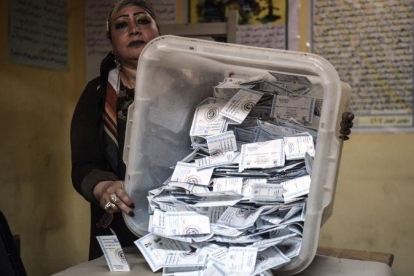 Una miembro de una mesa electoral muestra las papeletas depositadas en una urna en El Cairo.-AFP / MOHAMED EL-SHAHED