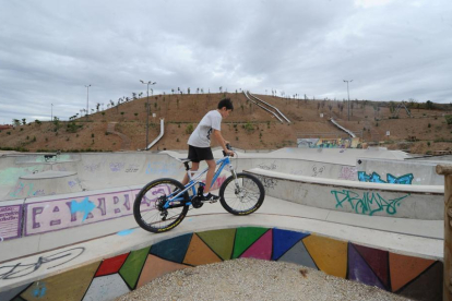 Un joven con una bicicleta en el parque de San Isidro. A partir de octubre se sembrarán las laderas.-ISRAEL L. MURILLO