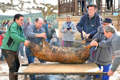 Vecinos con experiencia en la matanza cogen al gorrino bajo la atenta mirada de adultos y pequeños.-R.F.