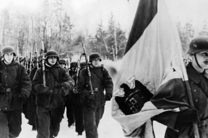 Integrantes de la División Azul, con el uniforme alemán de la 250 División de Infantería, desfila tras la bandera de la España de Franco camino de Leningrado.-ARCHIVO